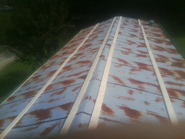Rusted metal roof panels with new wood purlins before replacement — Storm Damage Roof Repair in Astoria by Roofing Brothers
