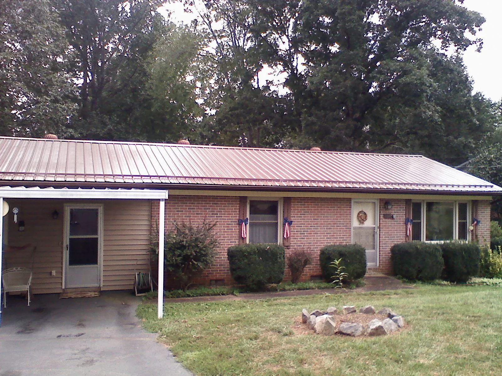 Bronze metal roof and carport on a brick ranch home — Roof Repair work by our crew in Astoria